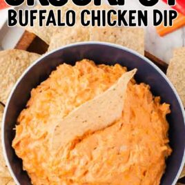 close up overhead shot of a bowl of Crockpot Buffalo Chicken Dip with a tortilla dipped into it served around tortilla chips