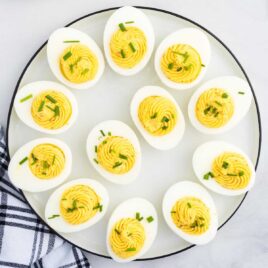 close up overhead shot of Deviled Eggs garnished with chives on a plate