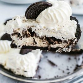 A piece of cake and ice cream on a plate, with Oreo