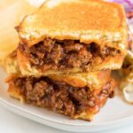 close up shot of Grilled Cheese Sloppy Joes served with chips on a plate