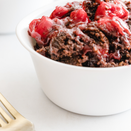 close up shot of chocolate cherry dump cake in a white bowl