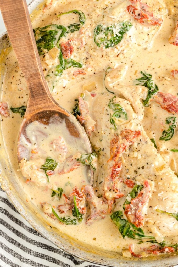 wooden spoon in pan with Tuscan Chicken