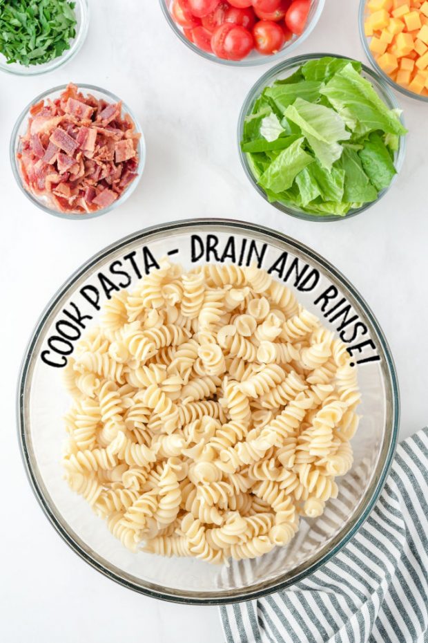 A bowl of food on a plate, with Salad and Pasta