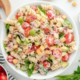 A bowl of salad on a plate, with BLT and Pasta