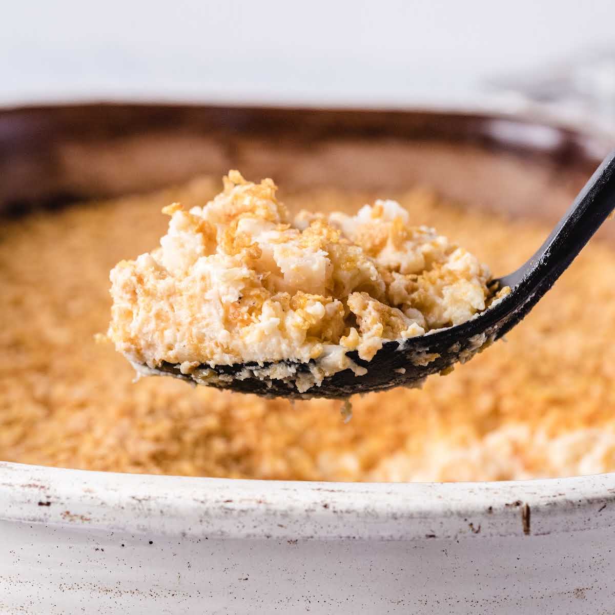 a close up shot of a spoon grabbing a piece of Funeral Potatoes
