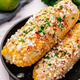 close up shot of Mexican Corn on the Cob topped with parsley