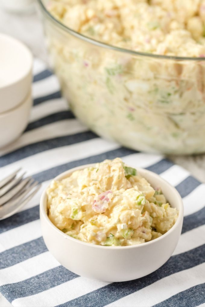 small bowl of potato salad in front of large bowl