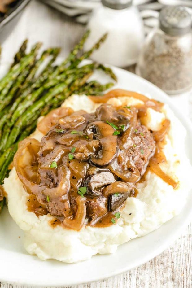 A close up of a plate of food, with Gravy and Salisbury steak