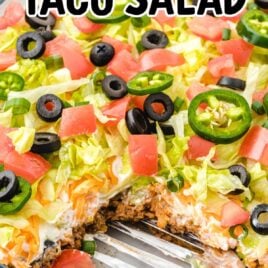 Layered Taco Salad in a baking dish with a spatula
