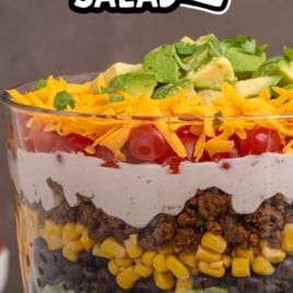 Layered taco salad in trifle dish with fresh toppings and text overlay layered taco salad fresh and so flavorful