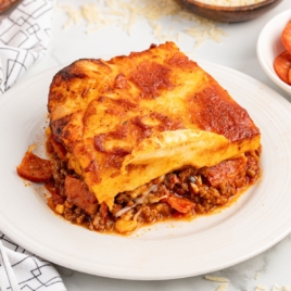 A plate with a slice of upside down pizza on it.