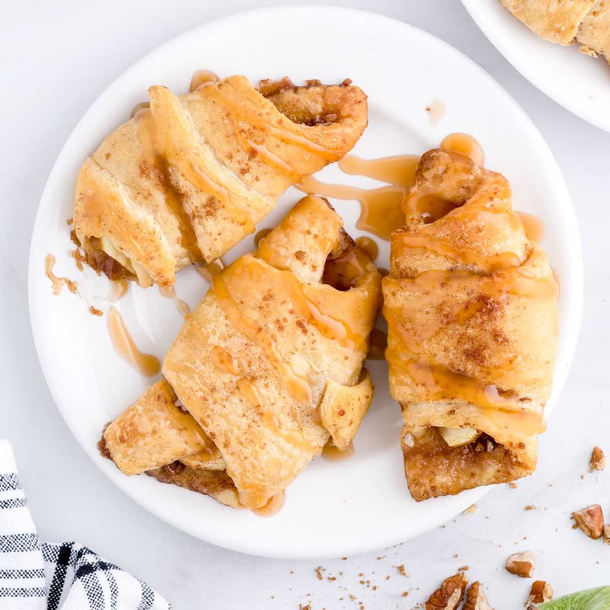 close up overhead shot of Apple Pie Bites drizzled with caramel sauce on a plate