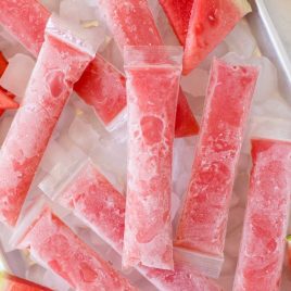 close up overhead shot of Boozy Popsicles with slices of watermelon served over ice