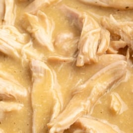 Text overlay image showing crockpot chicken and dumplings in thick gravy with slow cooker illustration.