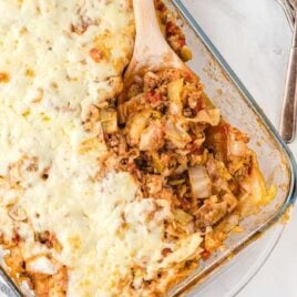 close up overhead shot of Cabbage Roll Casserole in a clear casserole dish with a wooden spoon