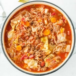 Close-up overhead shot of cabbage roll soup in a Dutch oven with tomato broth, cabbage, carrots, and ground beef