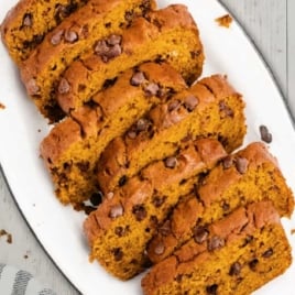 Sliced pumpkin chocolate chip bread served on a white platter.