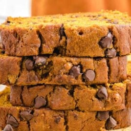 close up shot of chocolate chip pumpkin bread cut into slices and stacked on top of each other