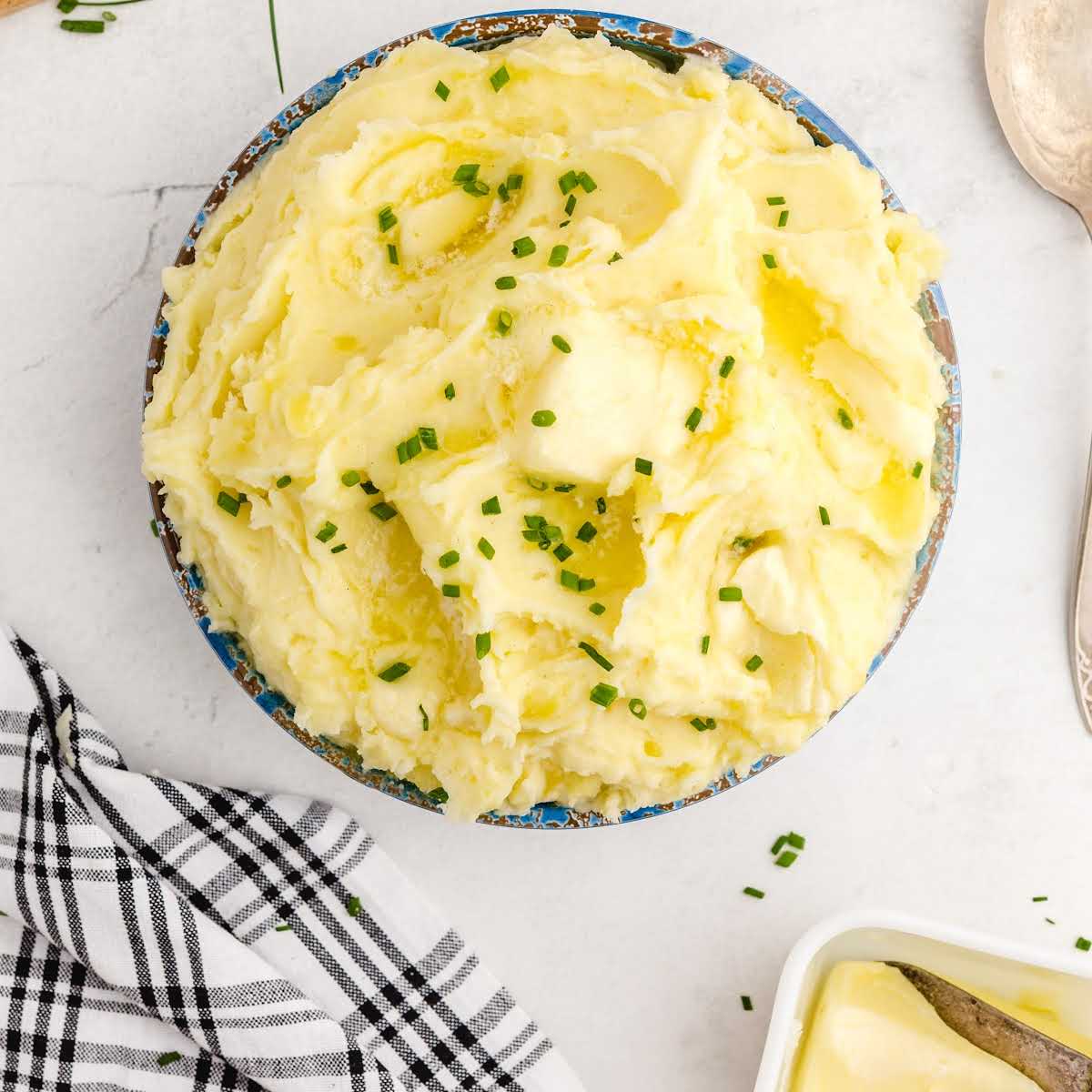 close up overhead shot of a bowl of Creamy Mashed Potatoes garnished with chives