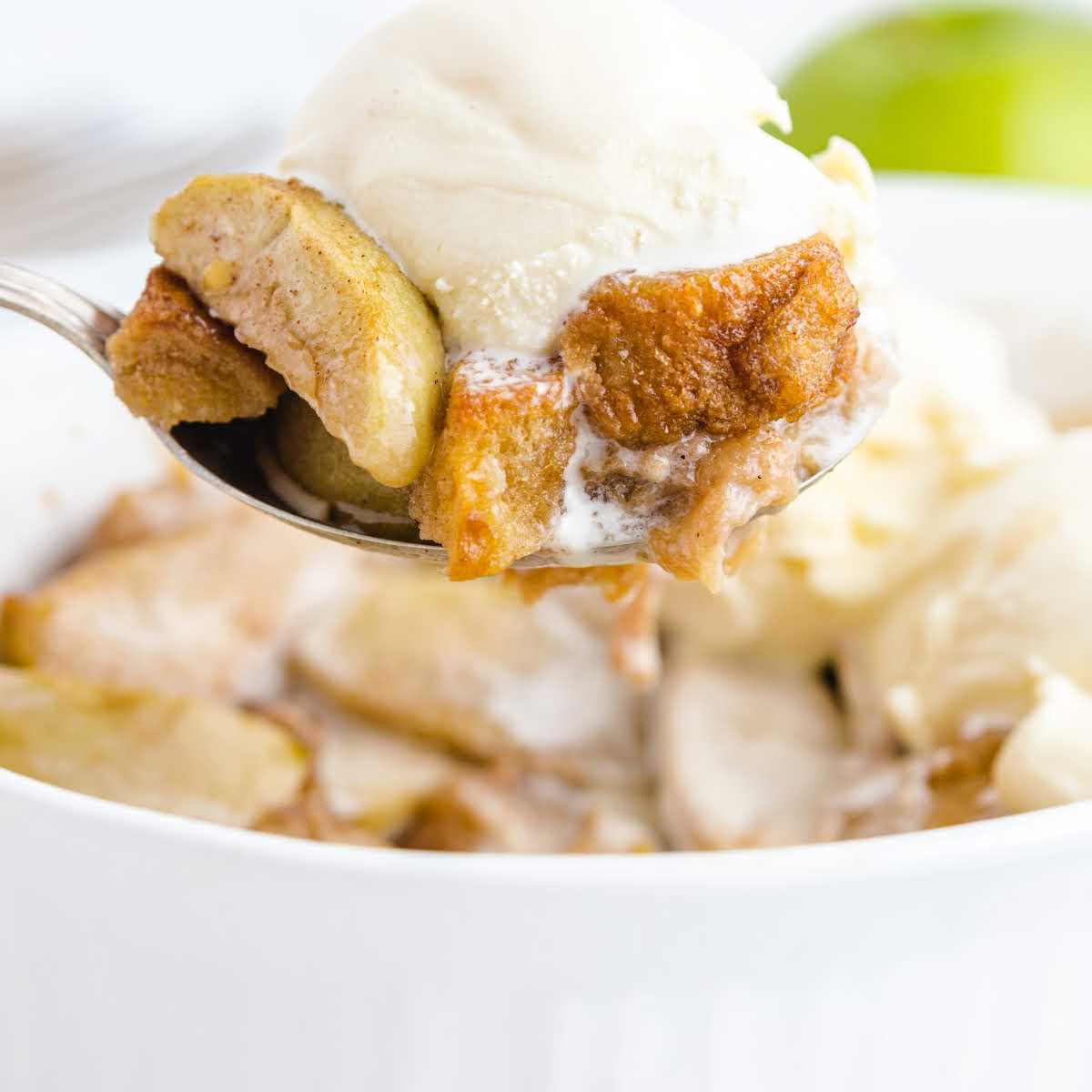 a close up shot of a spoon with a piece of Apple Betty