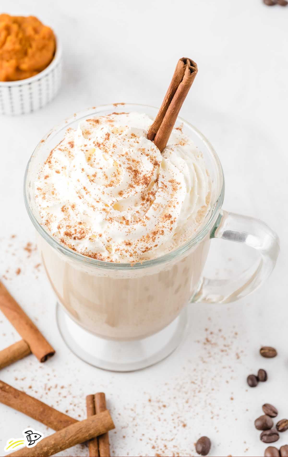 pumpkin spice latte in glass mug with whipped cream