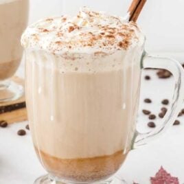 pumpkin spice latte in glass mug with whipped cream