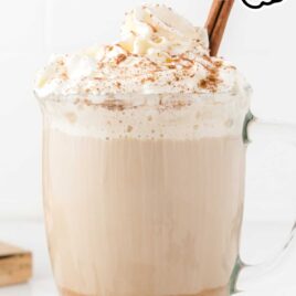close up shot of pumpkin spice latte in glass mug with whipped cream