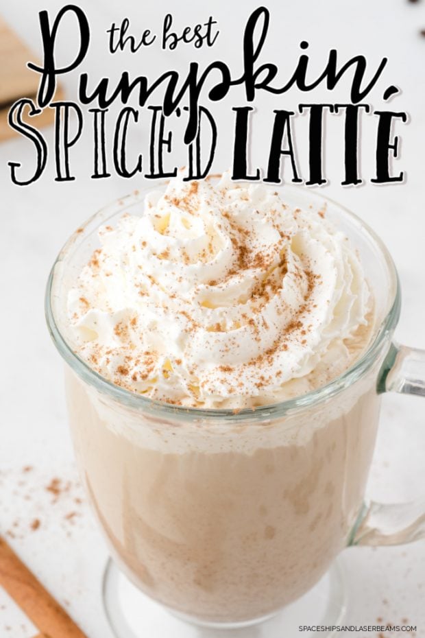 pumpkin spice latte in glass mug with whipped cream sitting on white surface