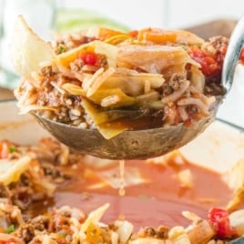 Ladle full of cabbage roll soup lifted over a pot with cabbage, rice, and beef in tomato broth; text overlay says 'The Best Recipe'