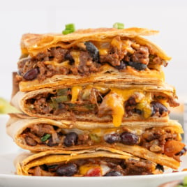 A stack of cut pieces of gooey, cheesy Sheet Pan Quesadillas.