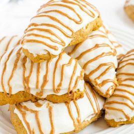 close up shot of Starbucks Copycat Pumpkin Scones piled on top each other on a white plate