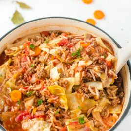 cabbage roll soup in a dutch oven with a spoon scooping out a serving
