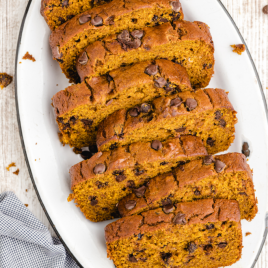 close up shot of chocolate chip pumpkin bread cut into slices on a white oval plate