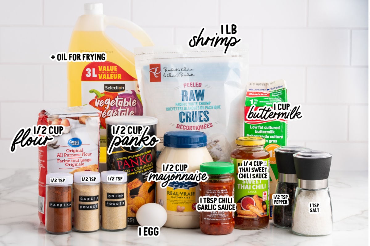 Ingredients for bang bang shrimp including raw shrimp, flour, panko breadcrumbs, egg, buttermilk, mayonnaise, Thai sweet chili sauce, chili garlic sauce, and spices.