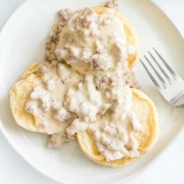 close up overhead shot of a plate of biscuits topped with sausage gravy
