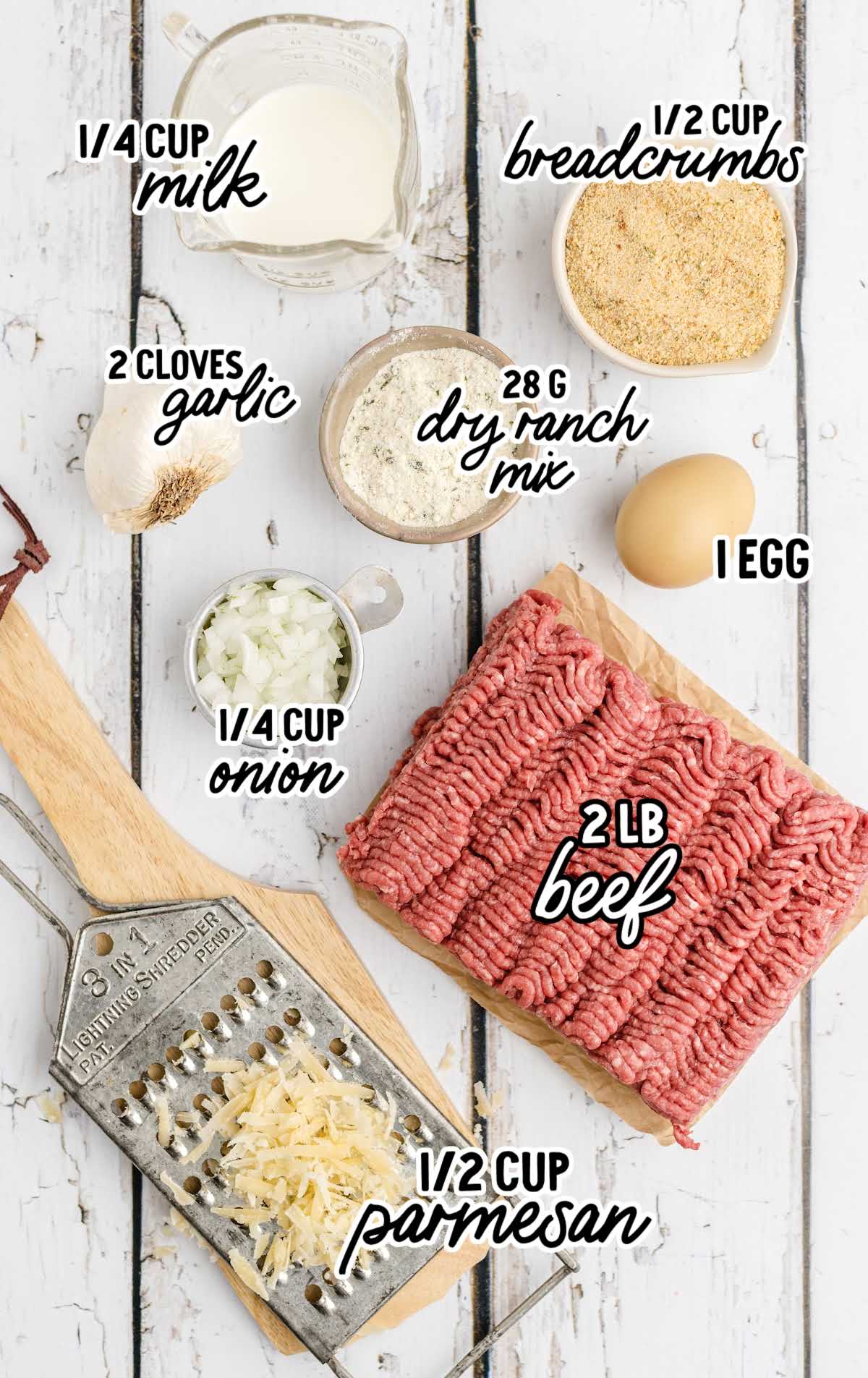 Flat lay of meatball ingredients including ground beef, egg, breadcrumbs, onion, garlic, parmesan, and ranch mix.