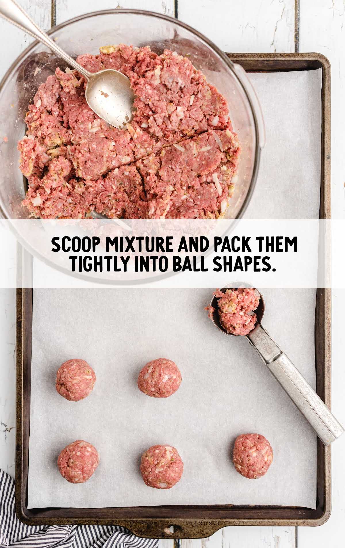 Raw meat mixture being formed into balls on a parchment-lined tray with a scoop in view.
