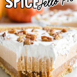 close up shot of a slice of Layered Pumpkin Spice Jello Pie topped with pecans on a plate