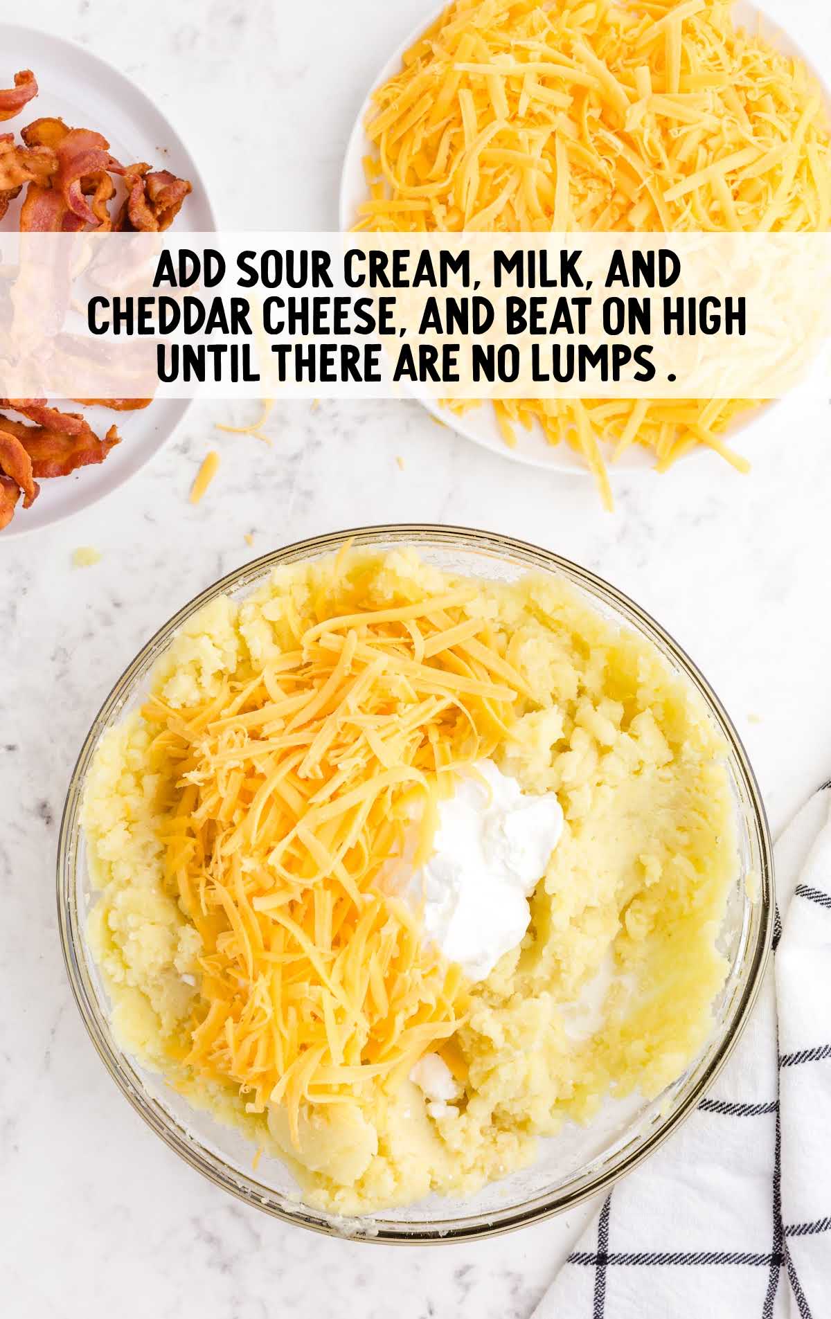 sour cream and cheddar cheese added to the butter mixture in a bowl