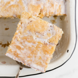 close up shot of cinnamon roll cake slice being picked up with a spatula
