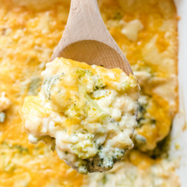 close up shot of broccoli and rice casserole on a wooden spoon