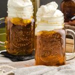 close up shot of jugs of Butterbeer topped with butter cream topping