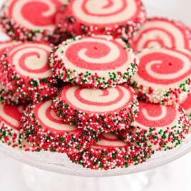 a close up shot of Christmas Pinwheels stacked on top of each other on a cake stand
