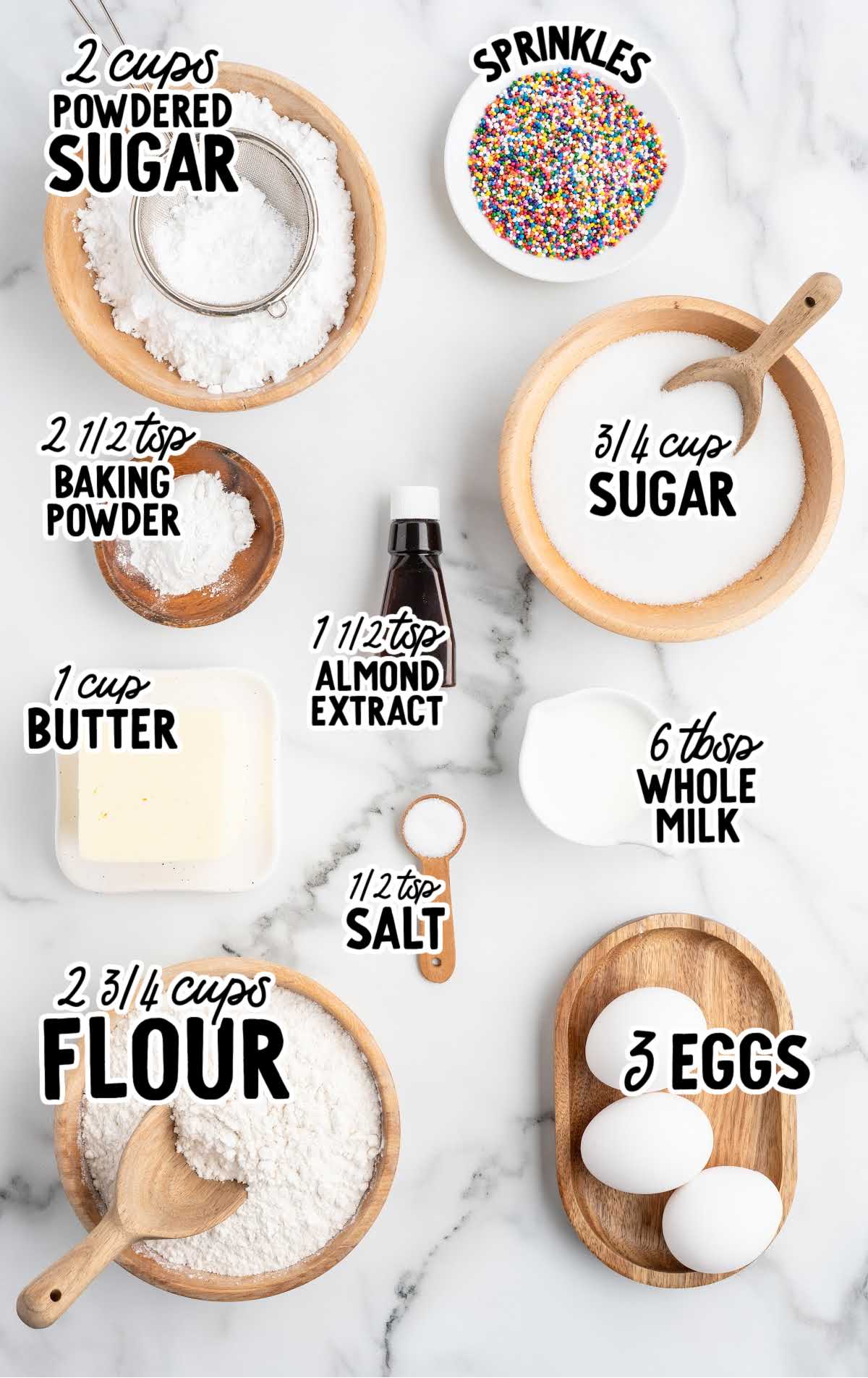 Labeled flat lay of ingredients for Italian cookies including flour, sugar, eggs, and sprinkles