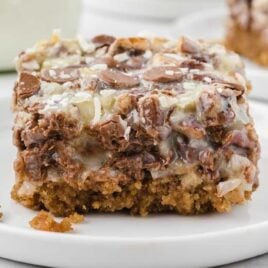 a close up shot of a slice of Magic Cookie Bars on a plate