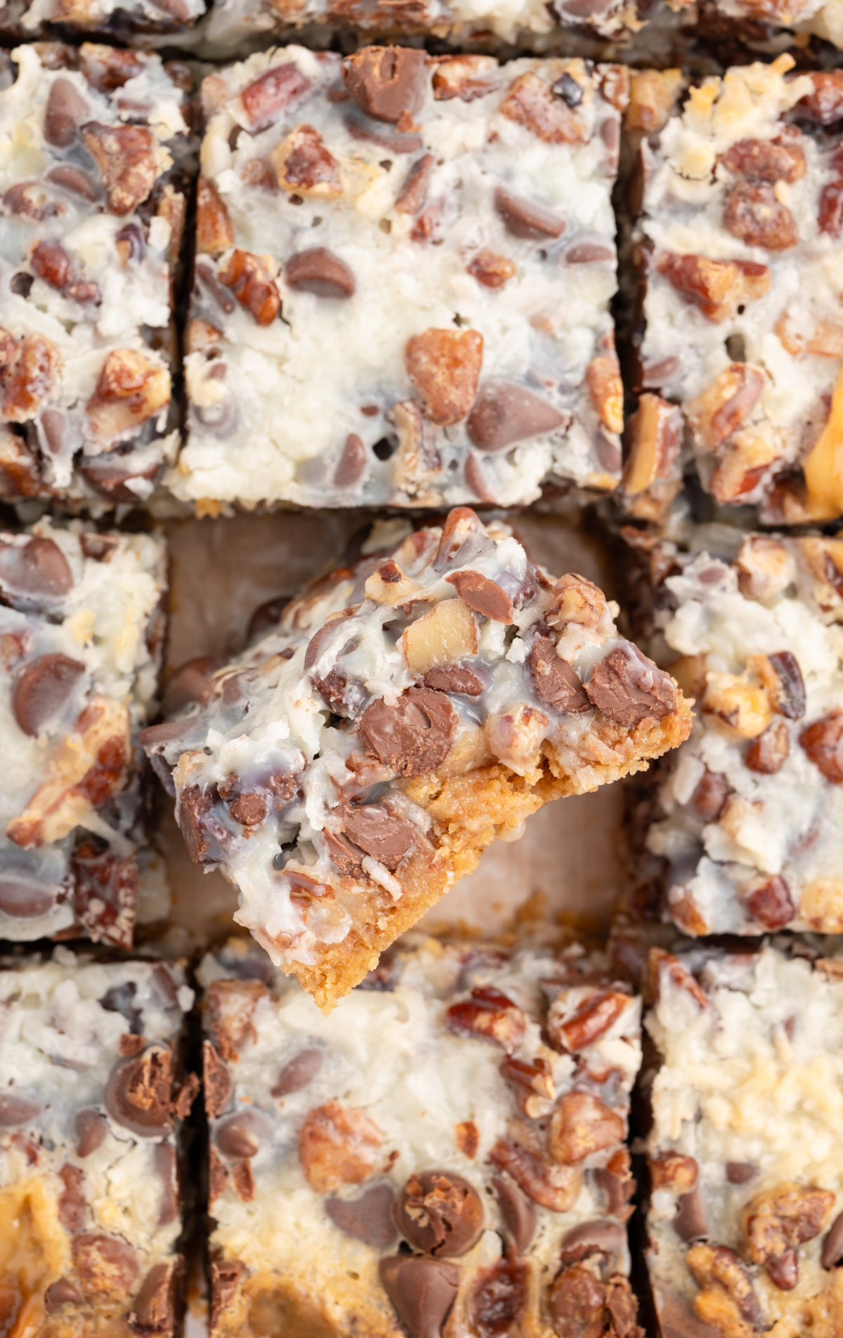 Cut magic cookie bars, and one is turned on it's side to show the layers. 