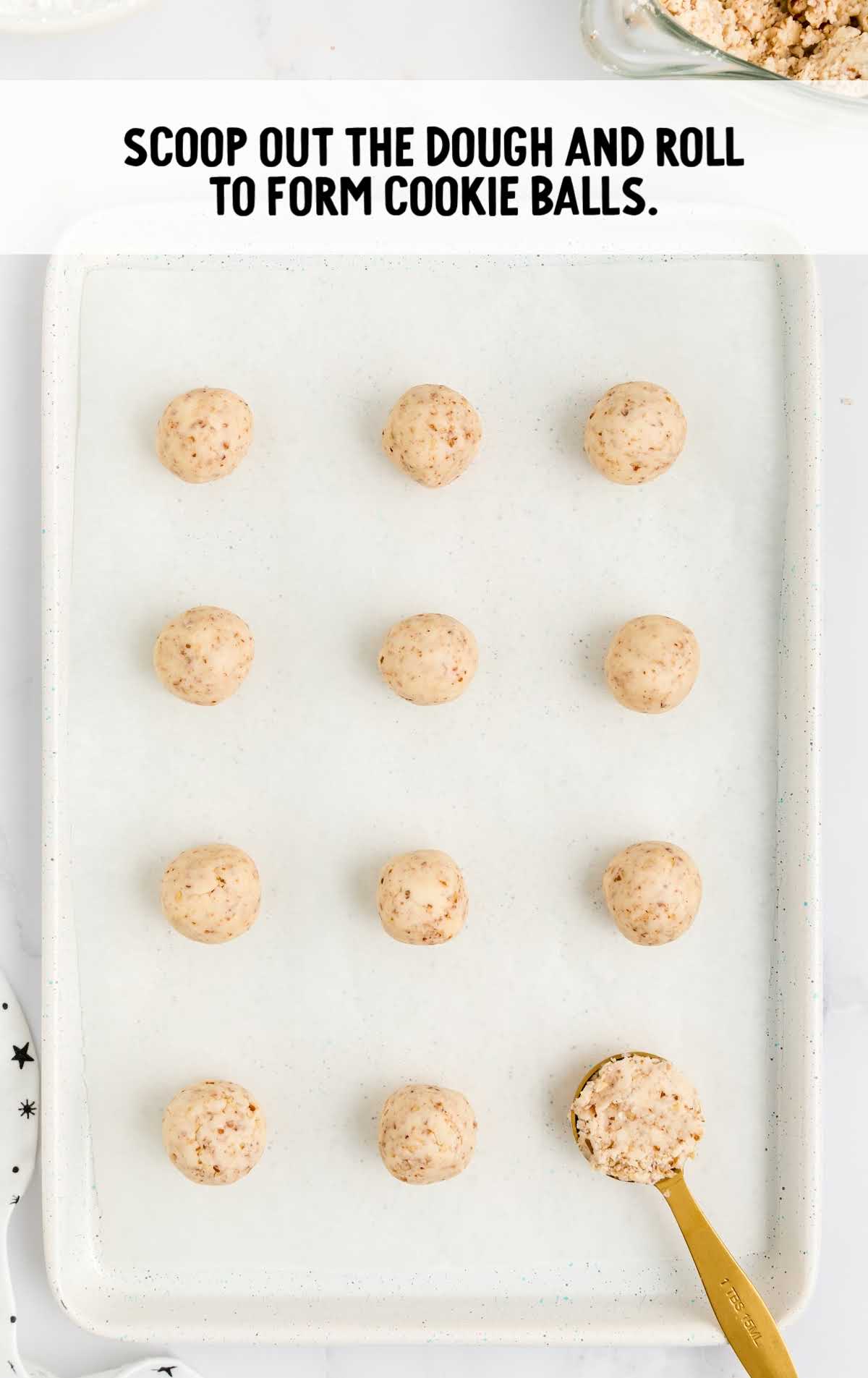 Snowball Cookies process shot of cookie dough balls scooped onto a sheet pan