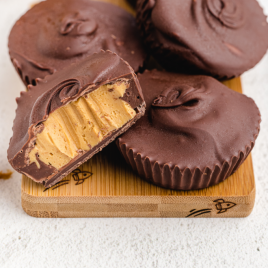 close up shot of homemade peanut butter cups stacked on a wooden board