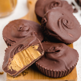 homemade peanut butter cups stacked on a wooden board