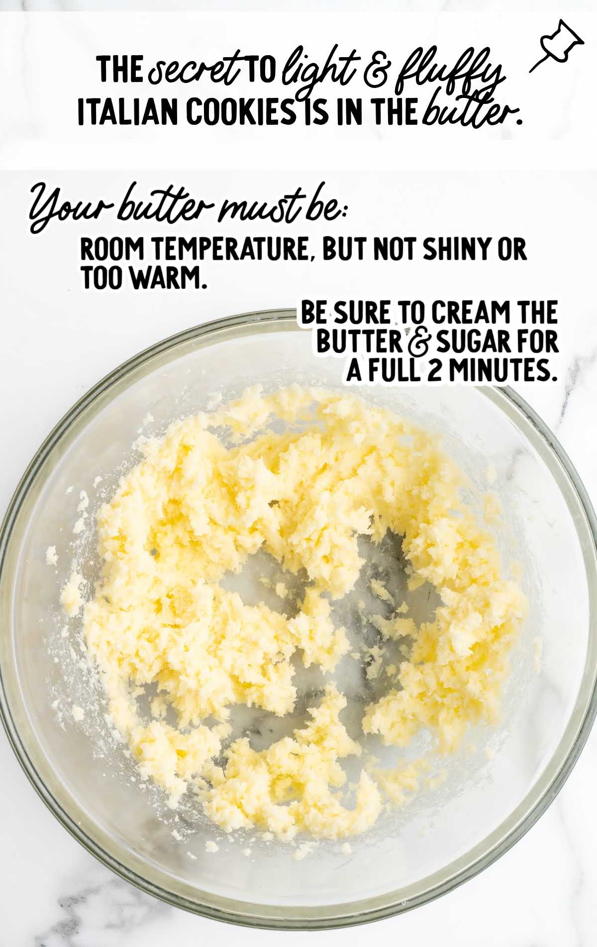 Butter and sugar creamed together in a glass bowl with text explaining the importance of room-temperature butter for light and fluffy Italian cookies